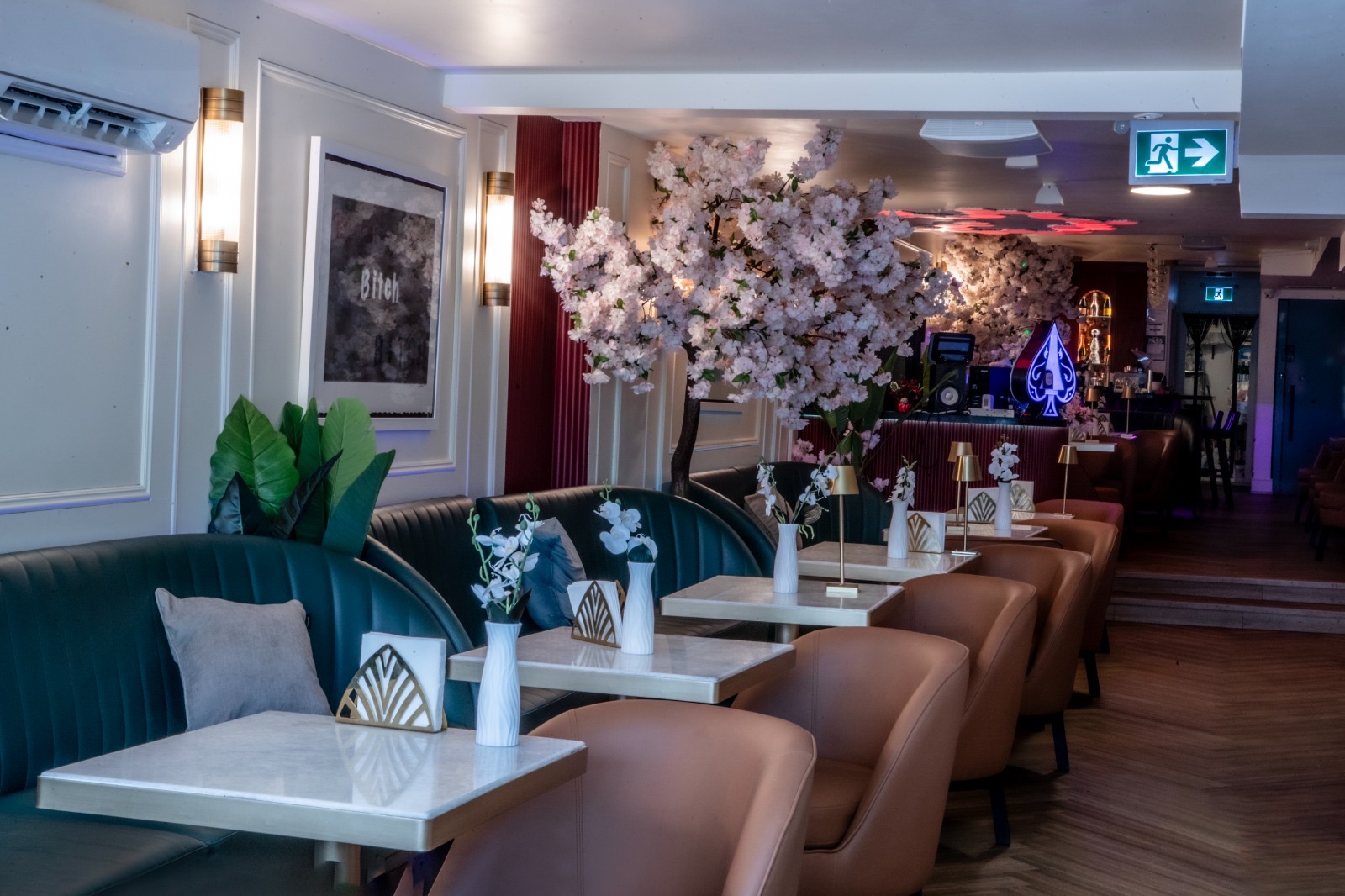 The Bar — Ace of Spades Centerpiece Art deco bar lit by blossoms with Ace of Spades centerpiece